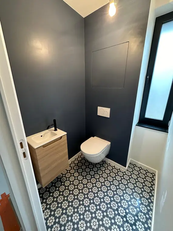 Toilettes en bleu profond, sol en carreaux à motif