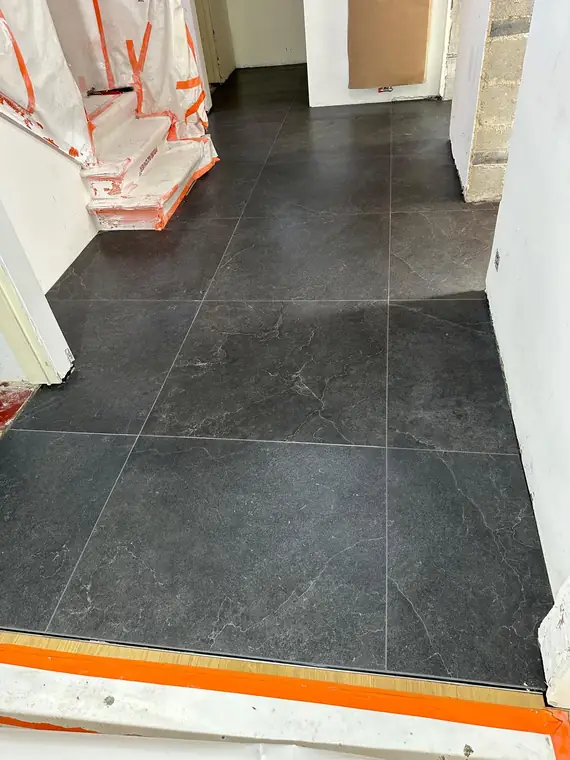 Grand carrelage foncé posé dans le hall
