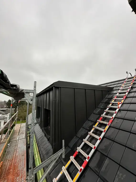 La lucarne en zinc vue depuis le versant en ardoises