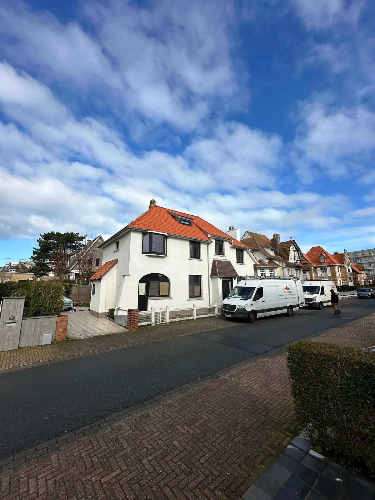 La maison terminée depuis la rue, façade blanche et toiture en tuiles